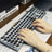 Person using a unique keyboard with decorative keys on a desk.