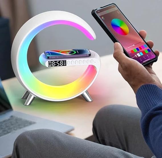 Colorful LED night light with smartphone charging pad and digital clock, held by a person.