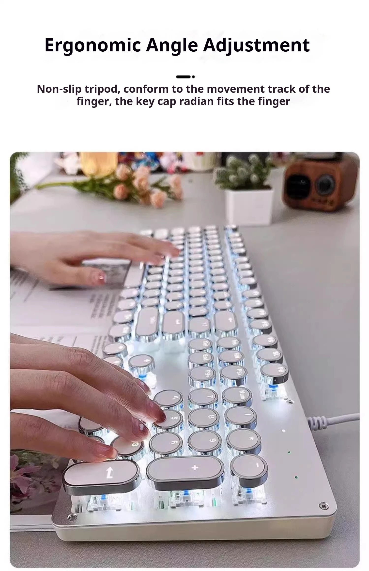 Ergonomic keyboard with hands typing on a desk with flowers and a camera in the background
