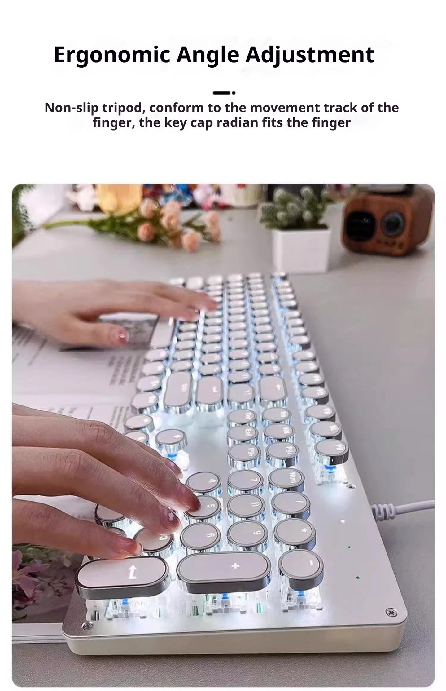 Ergonomic keyboard with hands typing on a desk with flowers and a camera in the background